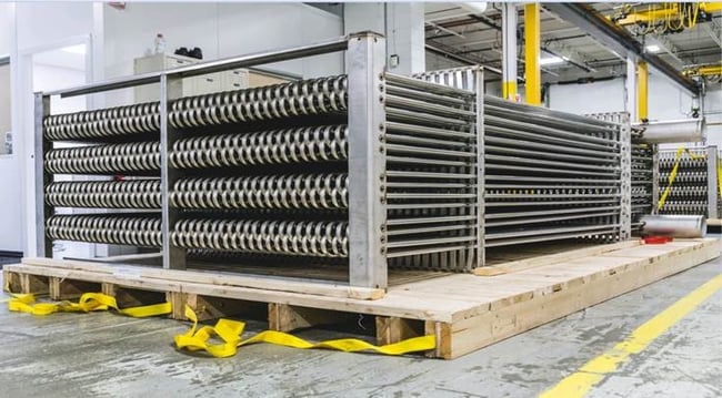 large bare-tube industrial heat exchanger in a factory setting 