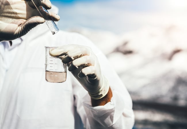 scientist in PPE testing water quality