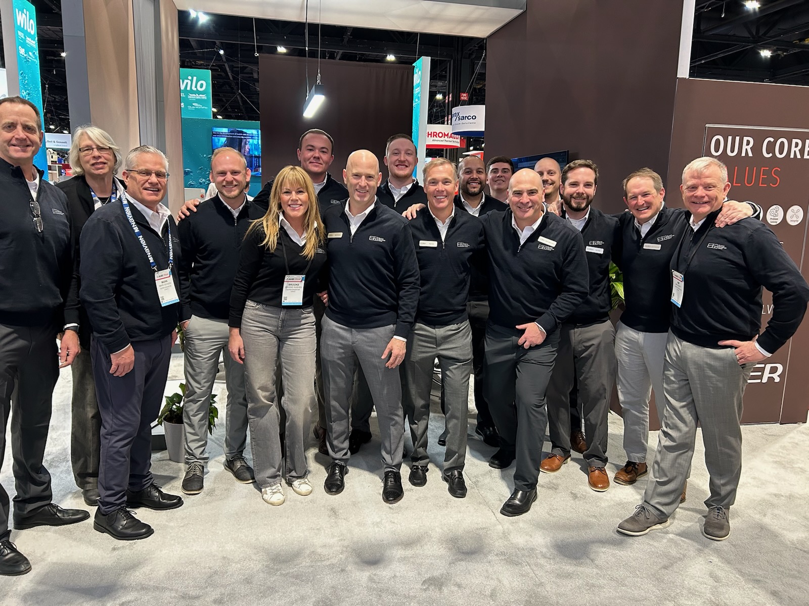 corporate group posing at a trade show booth