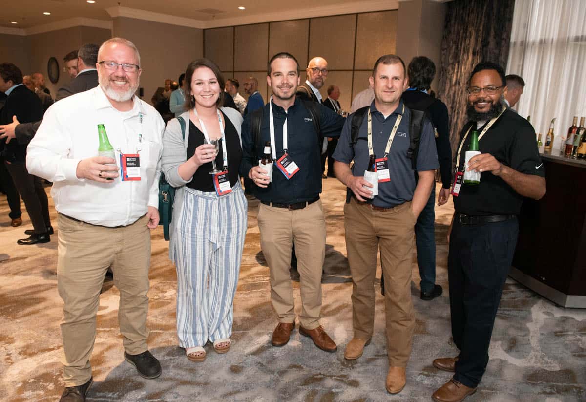 5 people standing at a reception with drinks