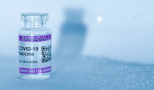 vial of COVID-19 vaccine against an icy backdrop