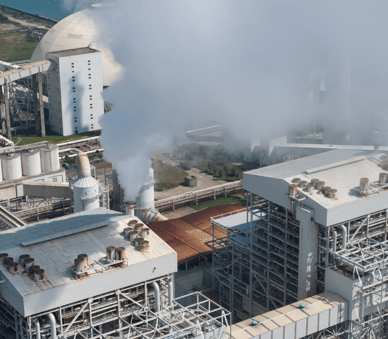 exterior image of factory with smoke coming from smokestack