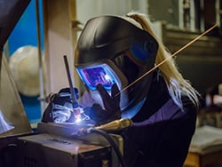 woman TIG welding an object