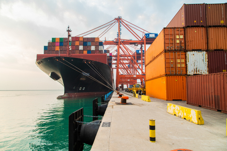 Photo of cargo ship in port laden with shipping containers 
