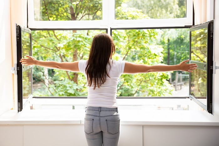 woman opening window on a nice day