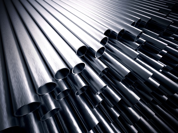 stack of gleaming stainless steel tubes against a black backdrop